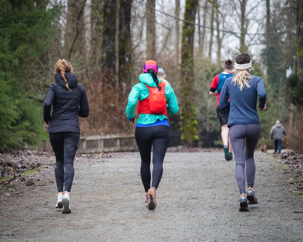 a group of people running down a dirt road