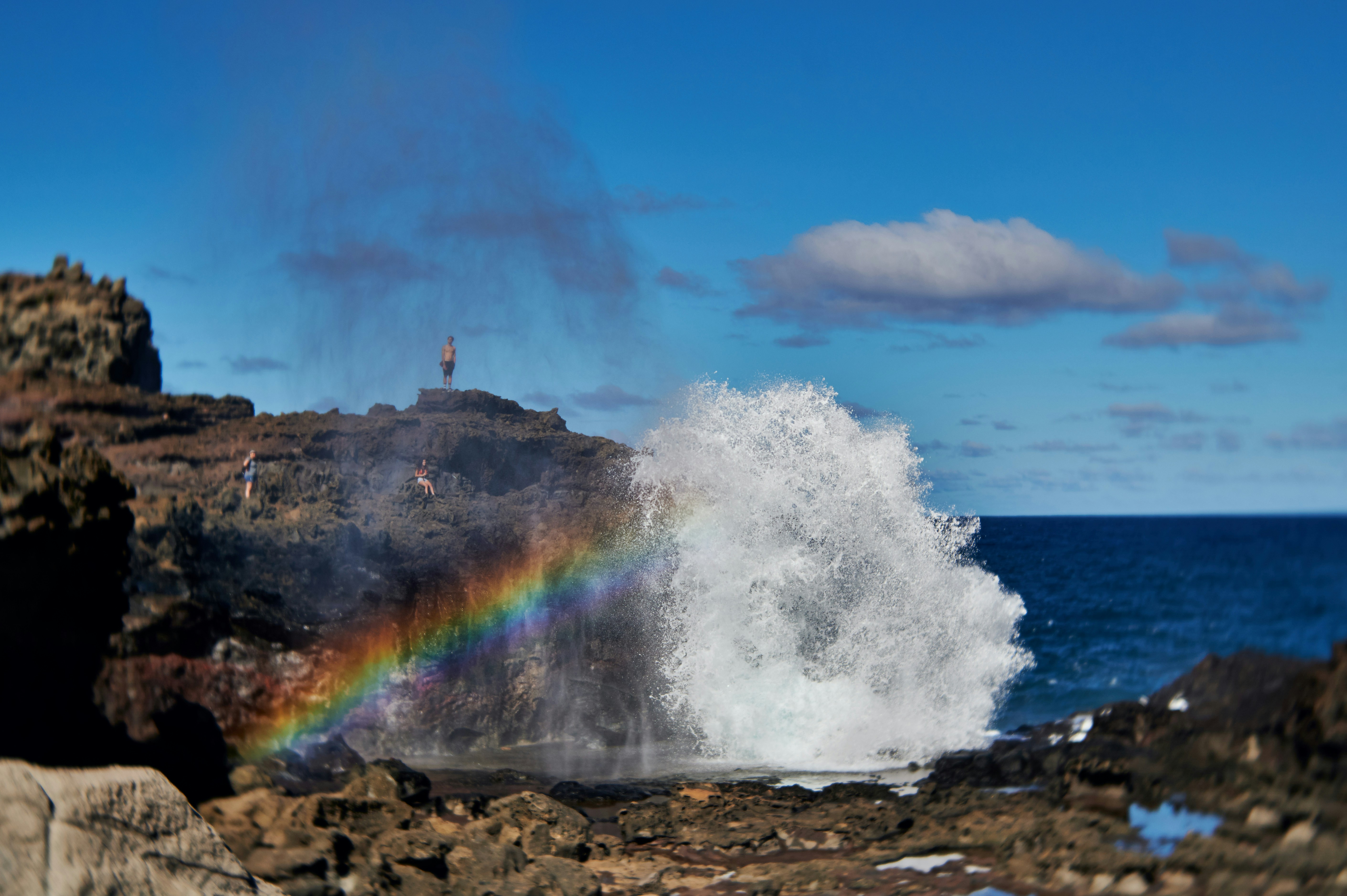 a rainbow in the sky over a body of water, The Nakalele Blowhole with a rainbow in the mist. Poelua Bay, Maui, Hawaii. Photographed with the Lensbaby Velvet for a vintage feel.