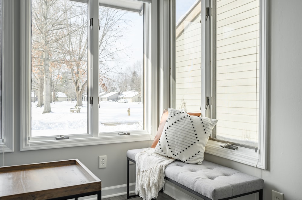 a window seat with a pillow on it in front of a window