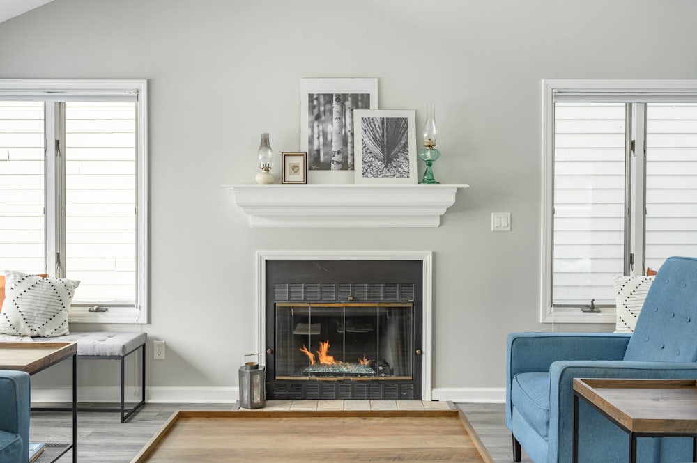 a living room with a fire place and blue chairs