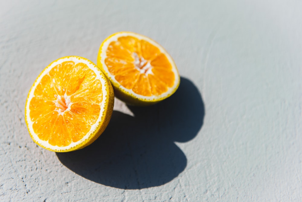 two oranges cut in half sitting on a table