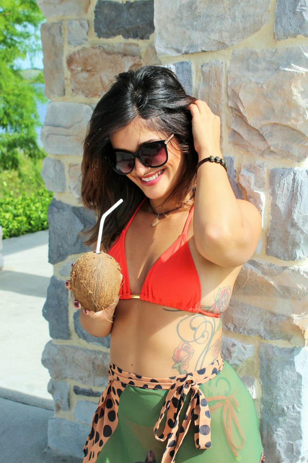 a woman in a bikini holding a coconut