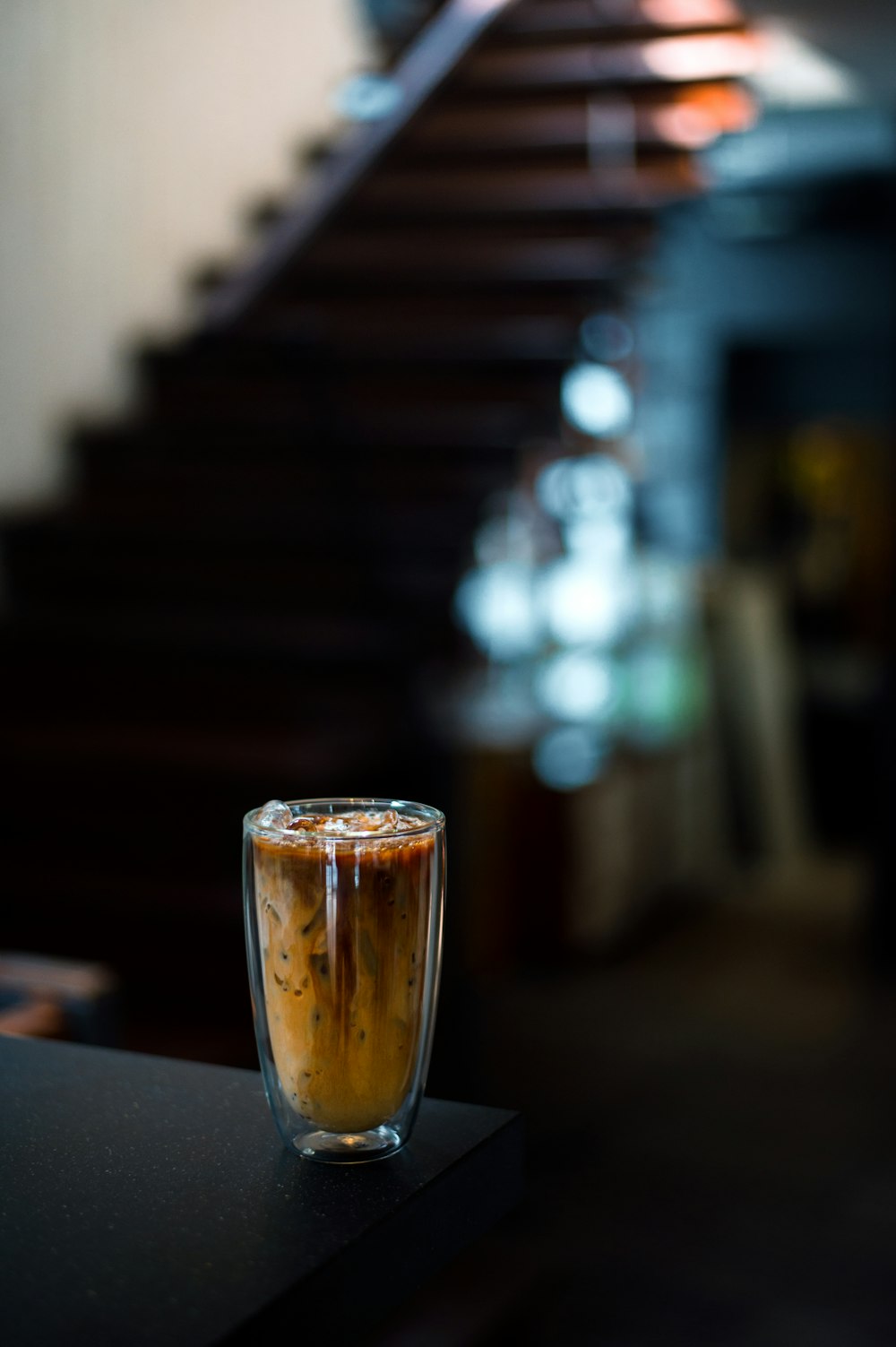 a glass of iced coffee sitting on top of a table