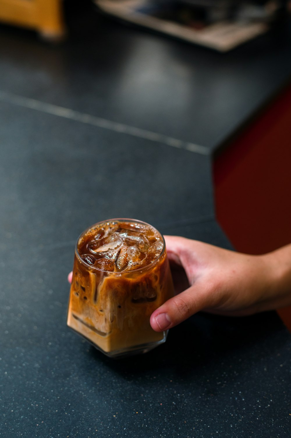 a person holding a cup of iced coffee