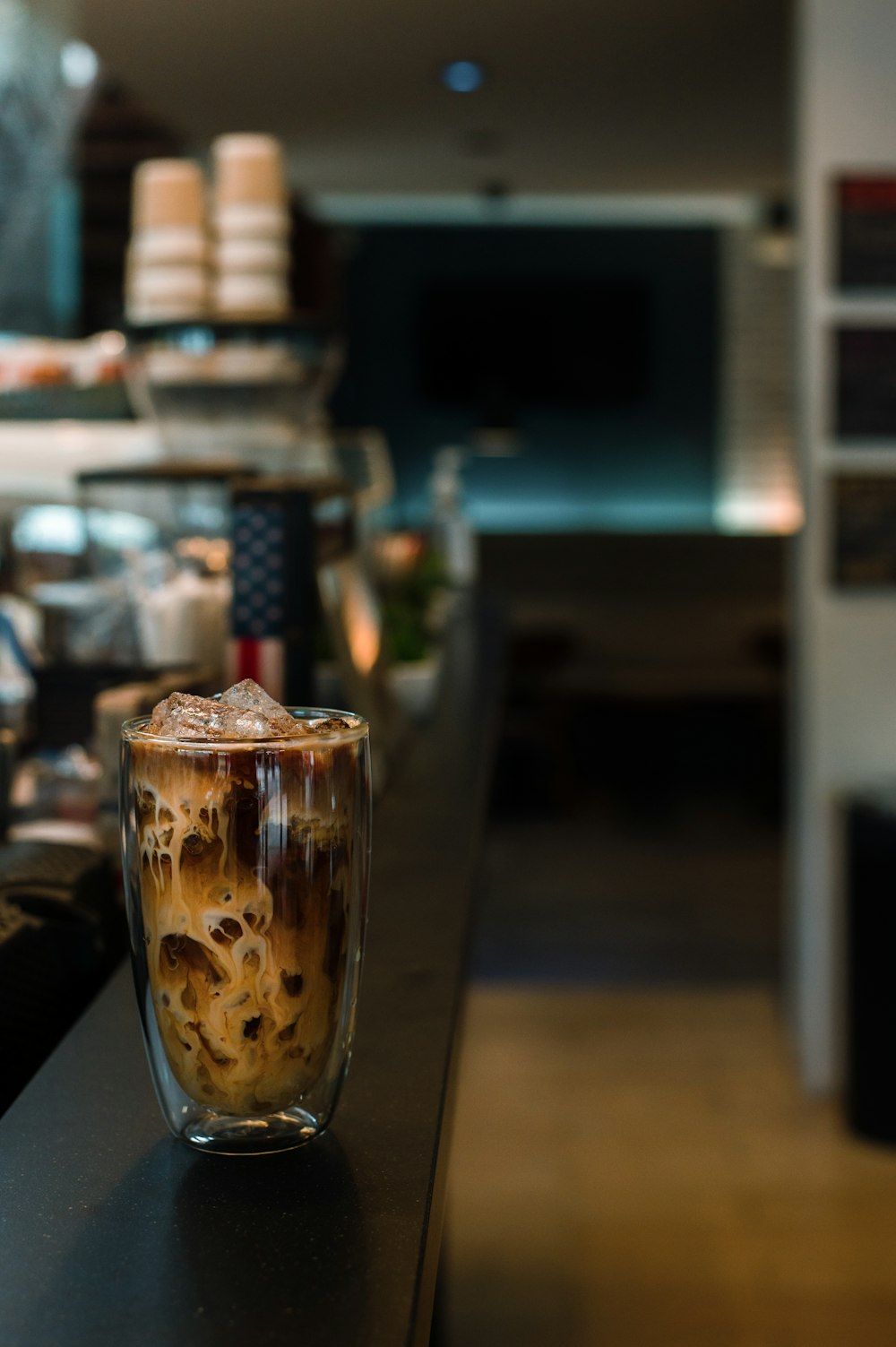 a glass of iced coffee sitting on a counter