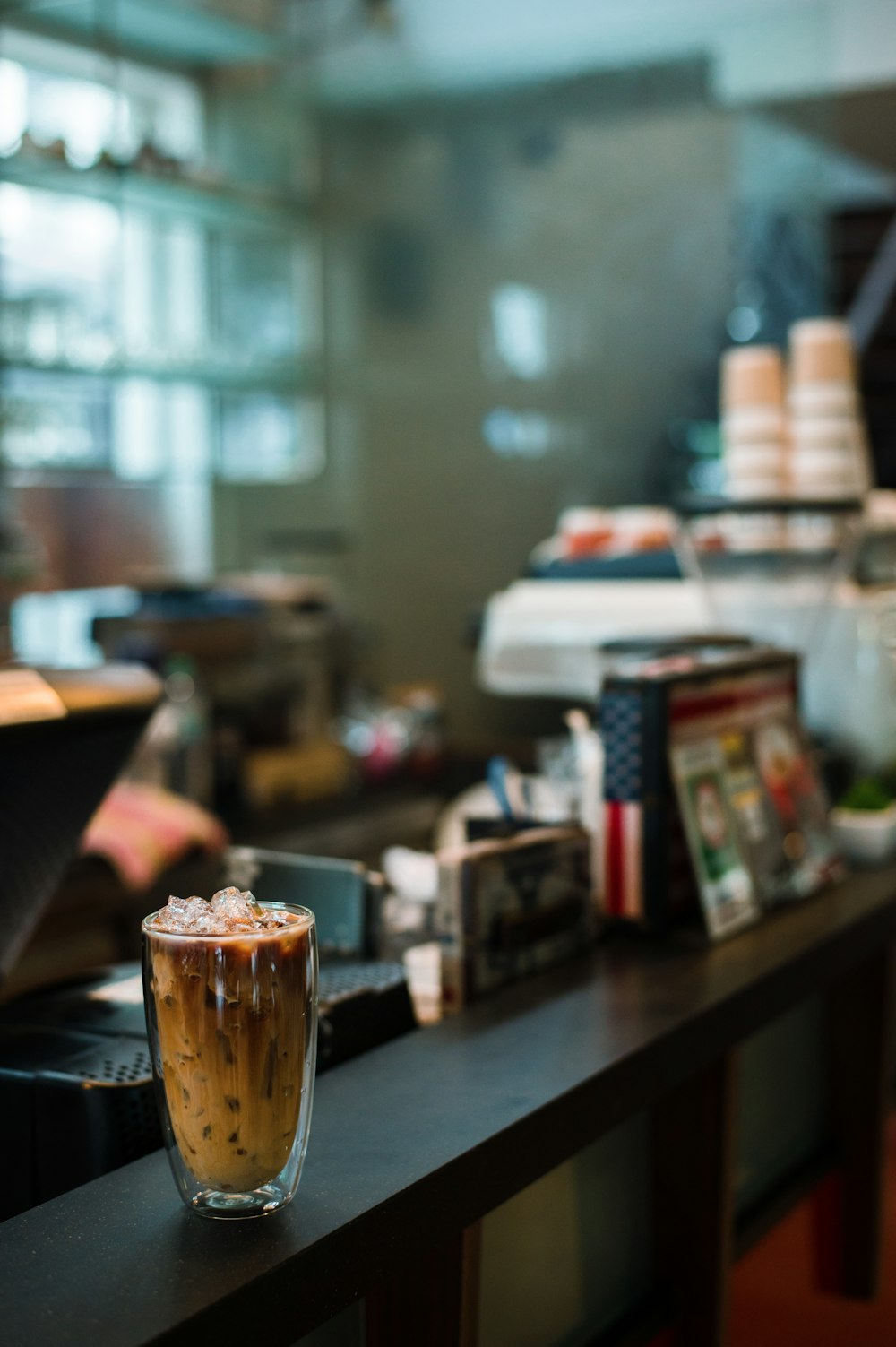 a glass of iced coffee sitting on top of a counter