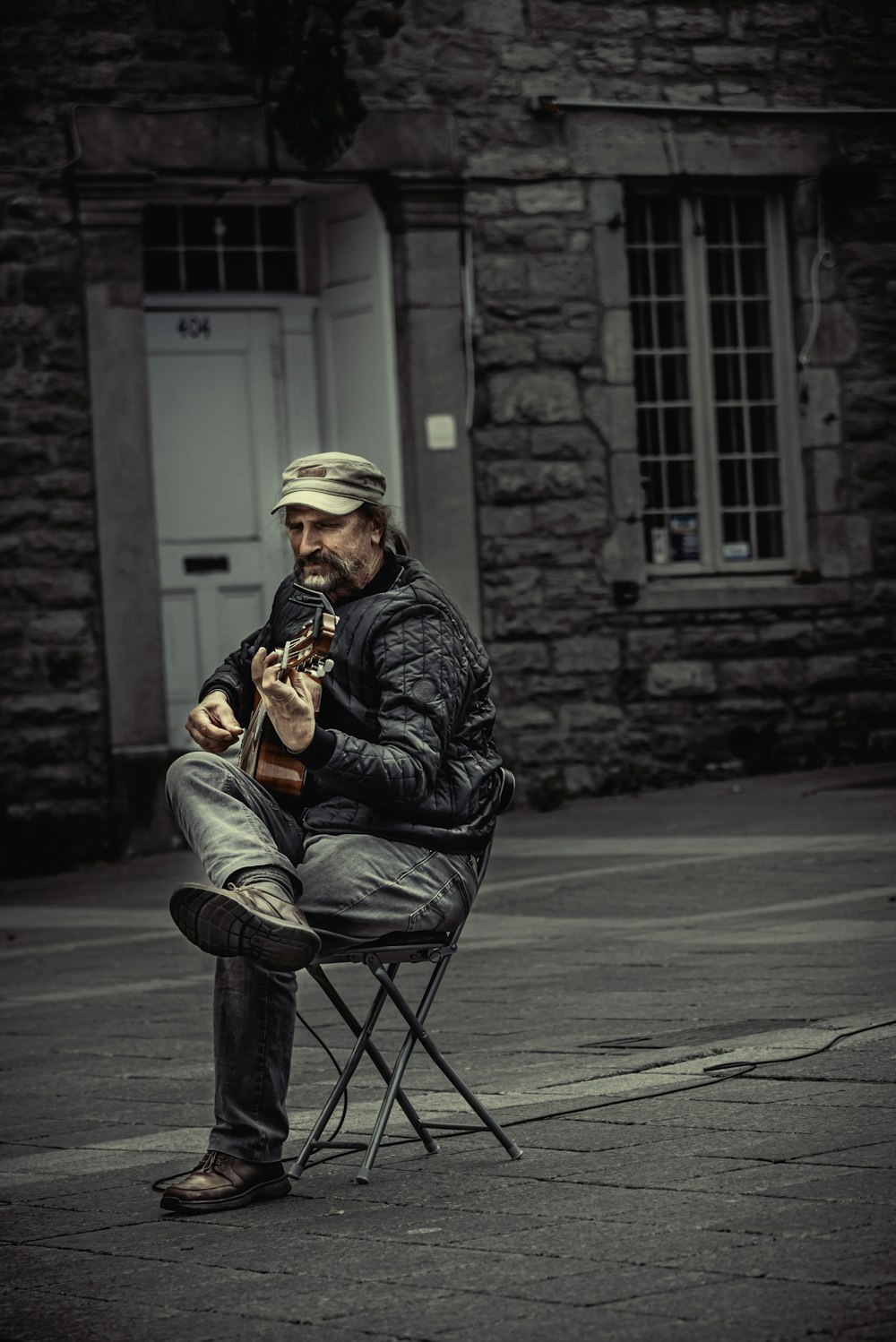 a man sitting in a chair playing a guitar