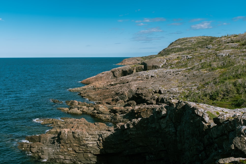 a large body of water sitting next to a lush green hillside