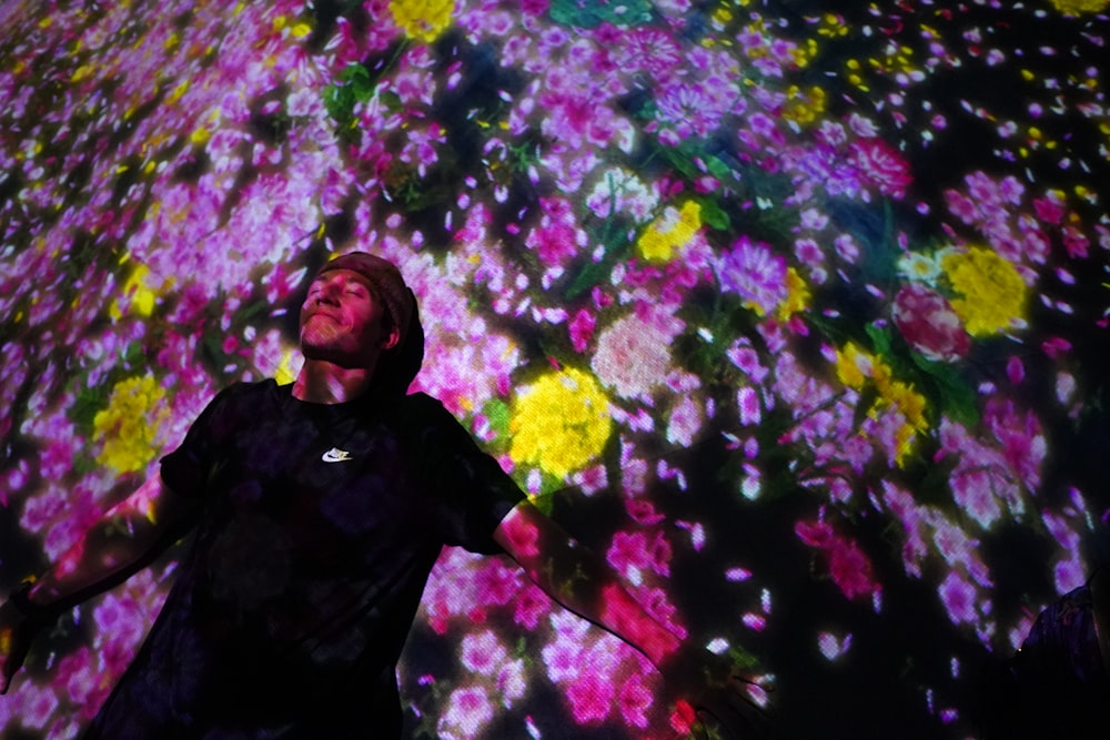 a man standing in front of a large display of flowers