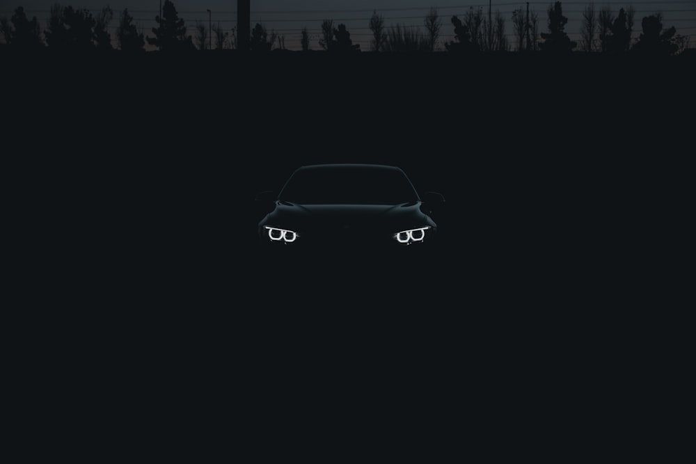 a car parked in a dark field at night
