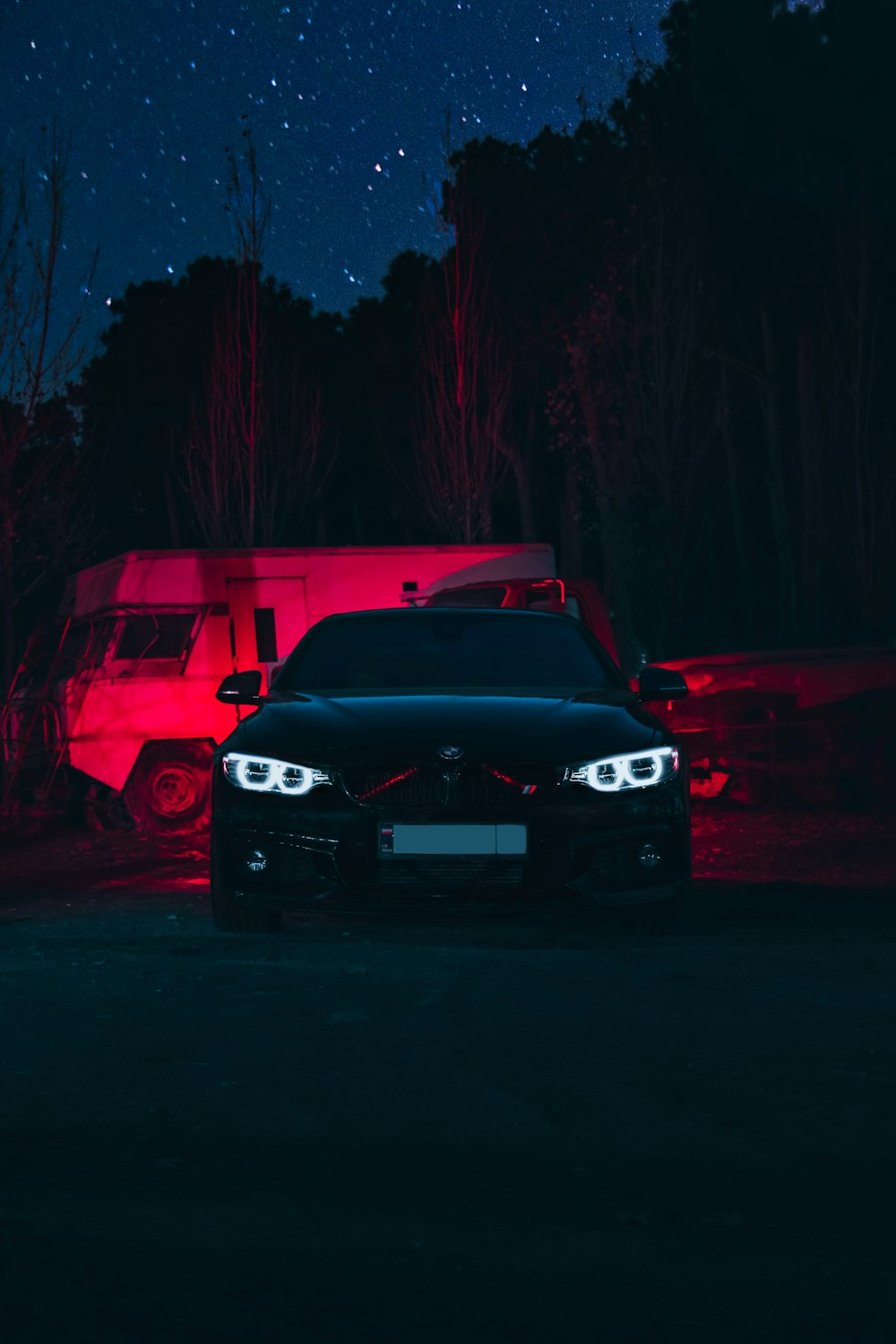 a car parked in front of a camper at night