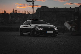 a black car parked in front of a mountain