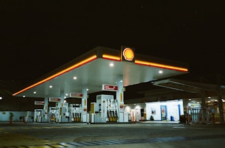 a gas station at night with a lit up gas station