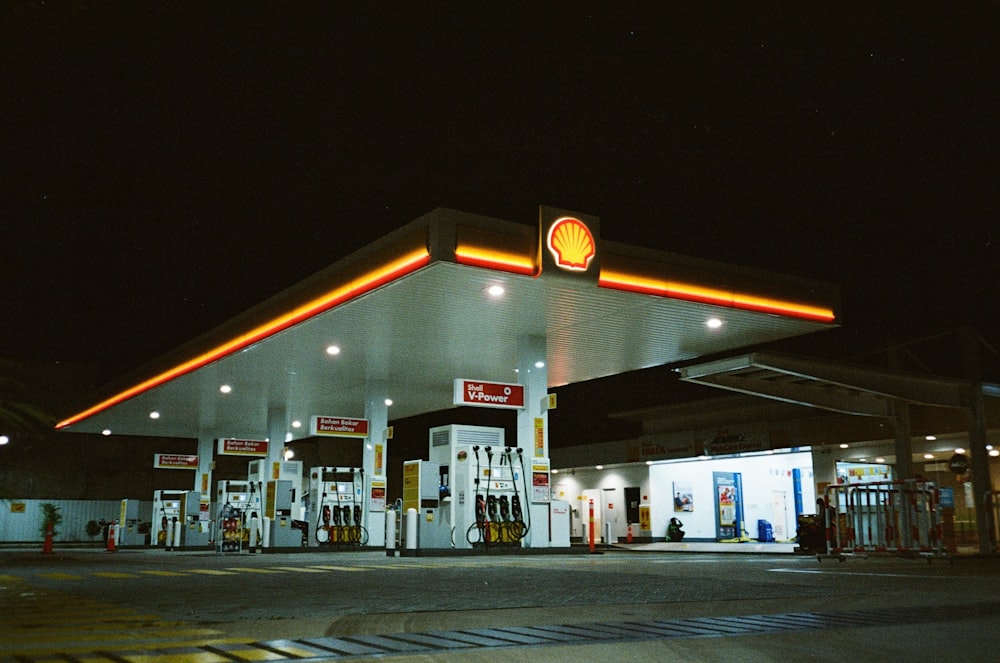 a gas station at night with a lit up gas station
