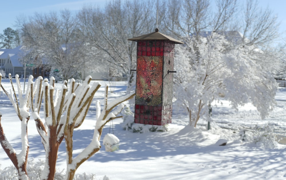 a bird feeder in the middle of a snowy yard