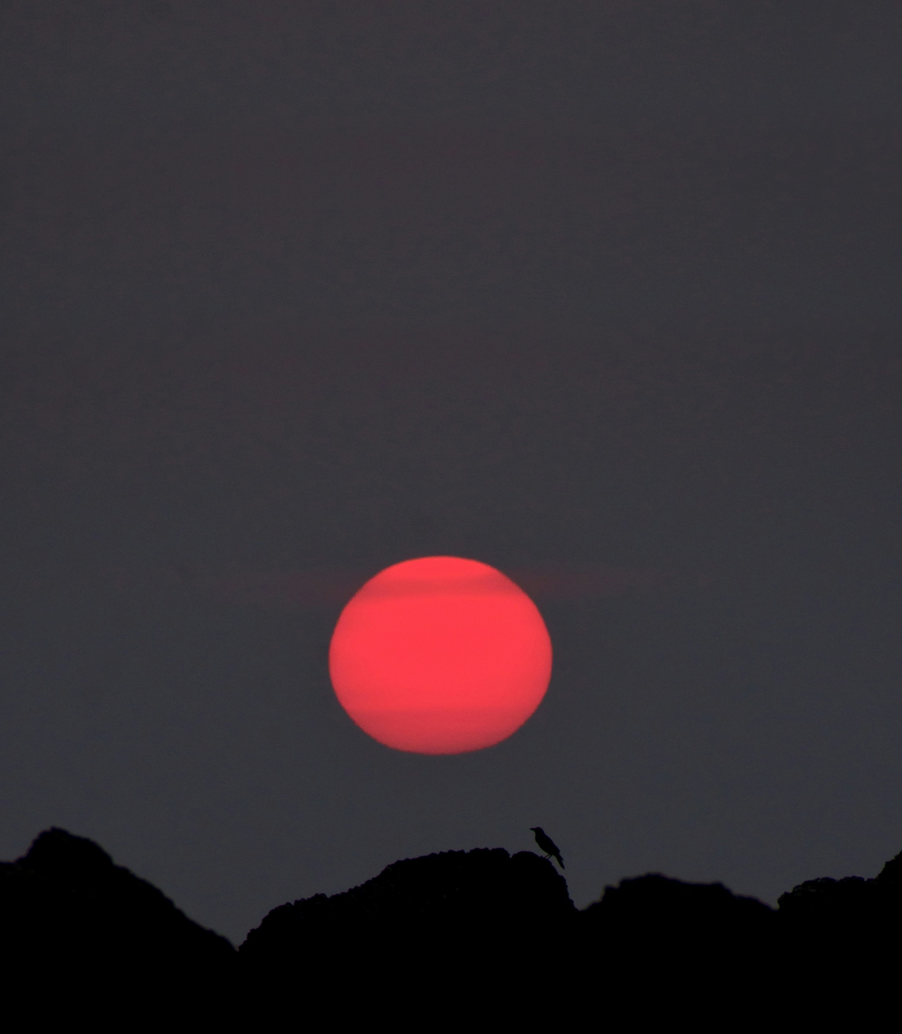 the sun is setting over a mountain range