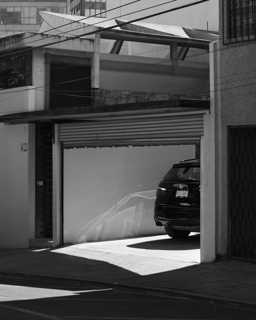 a black and white photo of a car parked in a garage