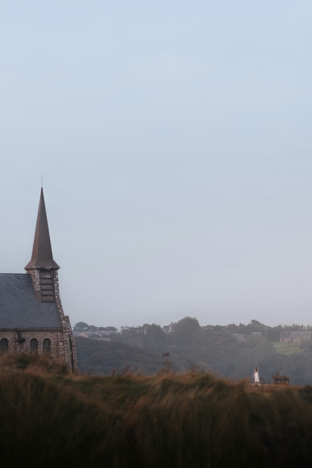 a church with a steeple on a hill