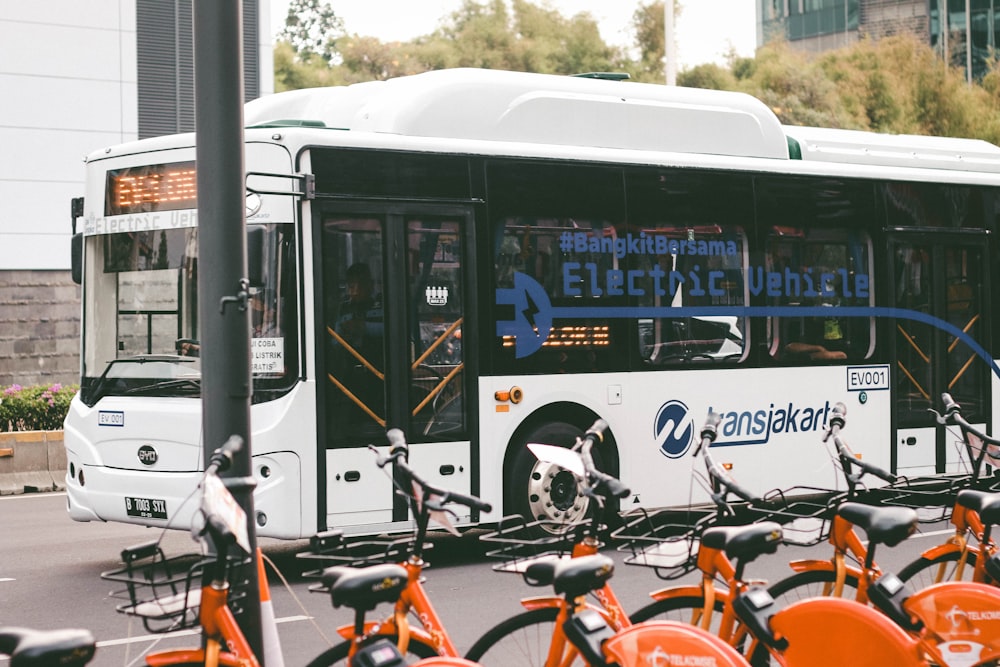 Ein Stadtbus parkt neben einem Haufen Fahrräder