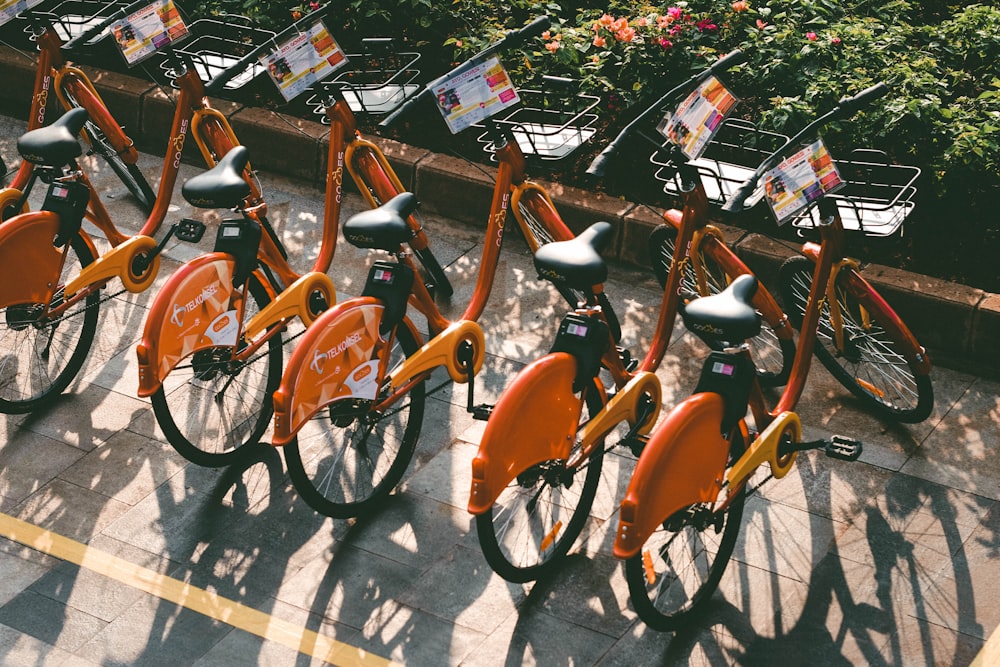 a row of orange bikes parked next to each other
