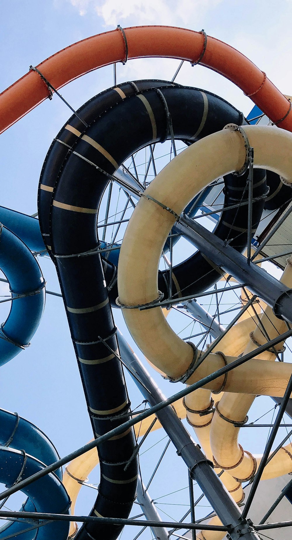 a close up of a water slide with a blue sky in the background