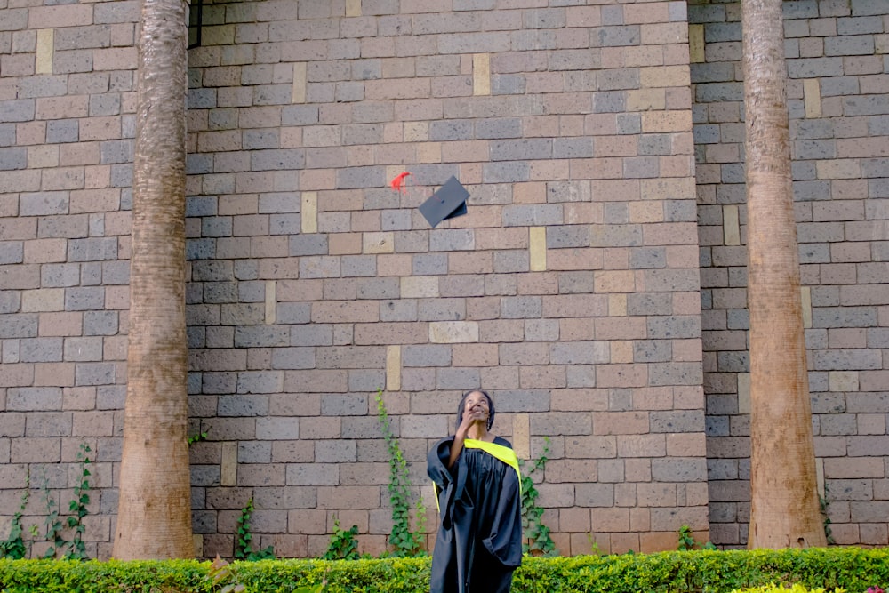 a woman in a graduation gown throwing a graduation cap in the air