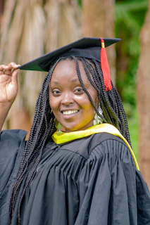 A smiling student holding a finished, polished capstone paper with a Culmen logo in the background