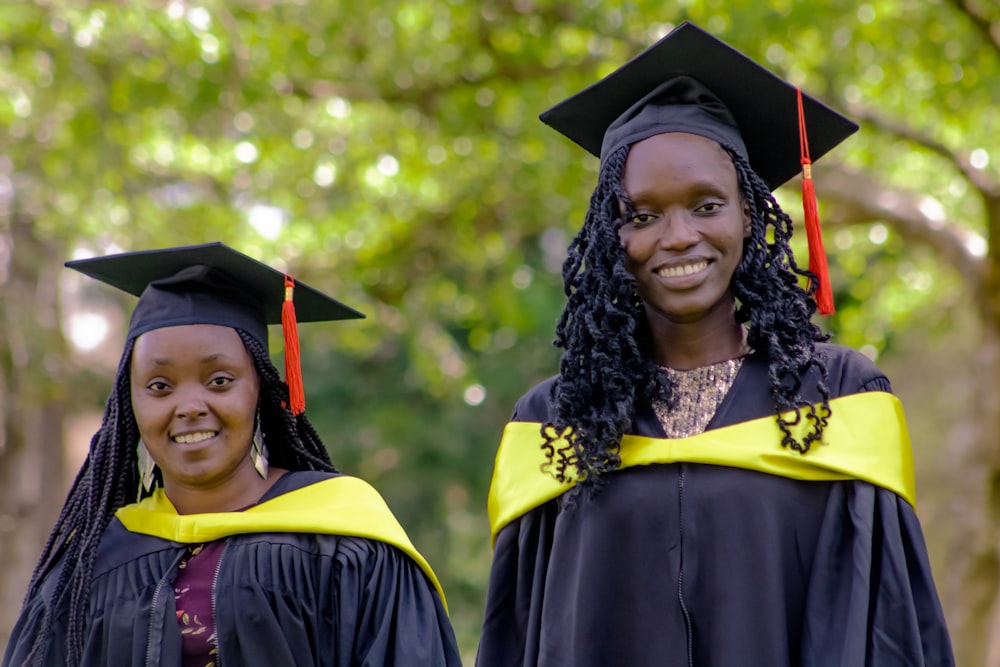 two women in graduation gowns standing together