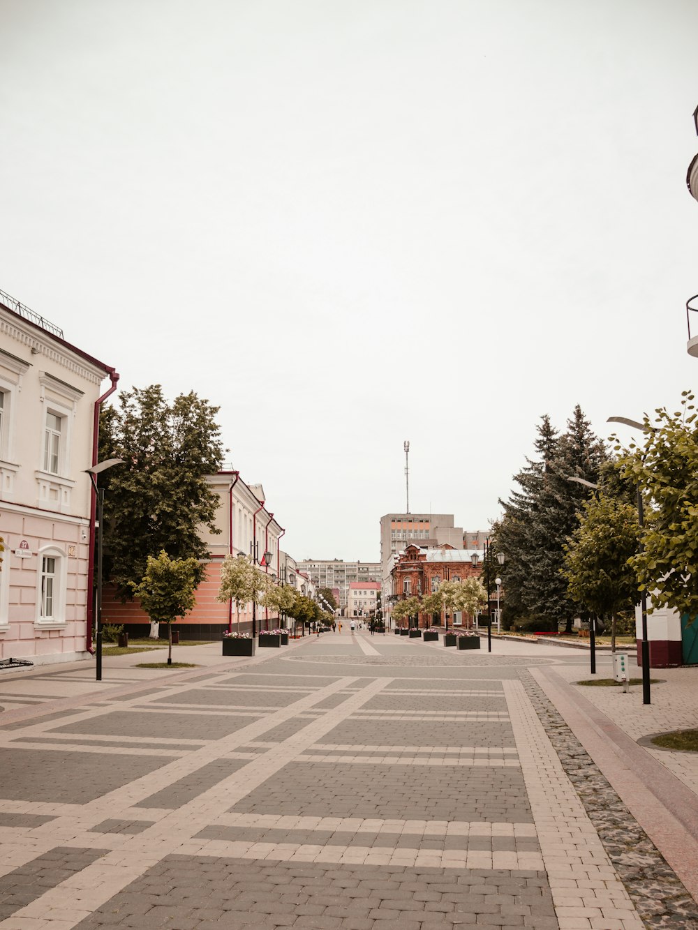 an empty street with a clock tower in the distance