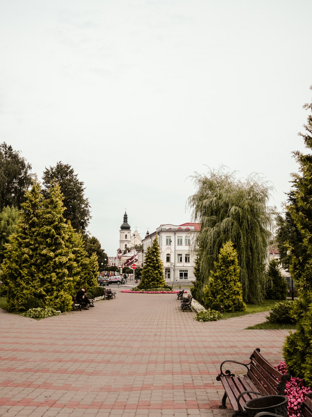 a bench sitting on a brick walkway in front of a building