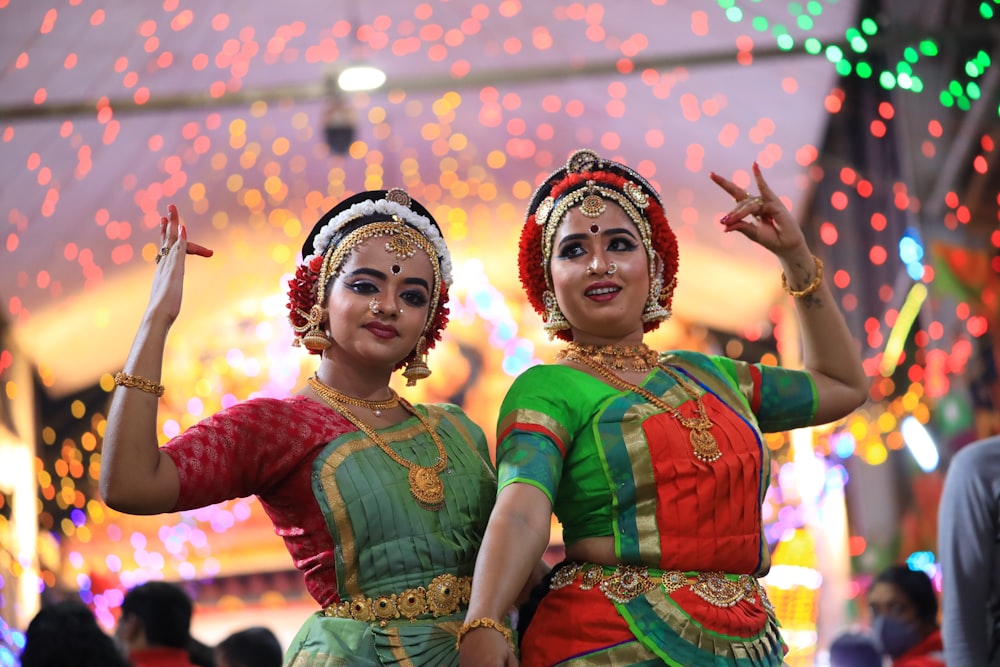 two women dressed in traditional indian garb dancing
