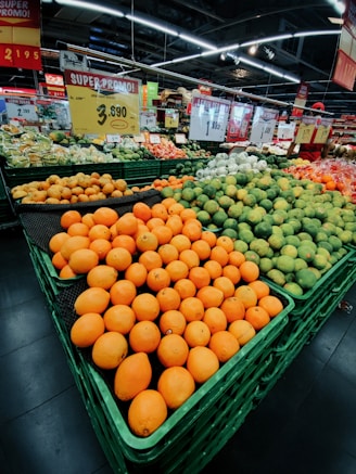 a produce section of a grocery store filled with oranges and melons