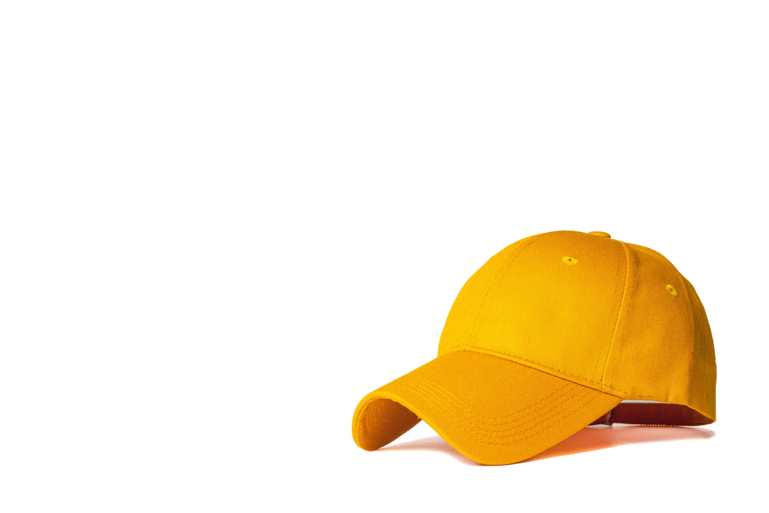 A plain mustard yellow baseball cap on a white background