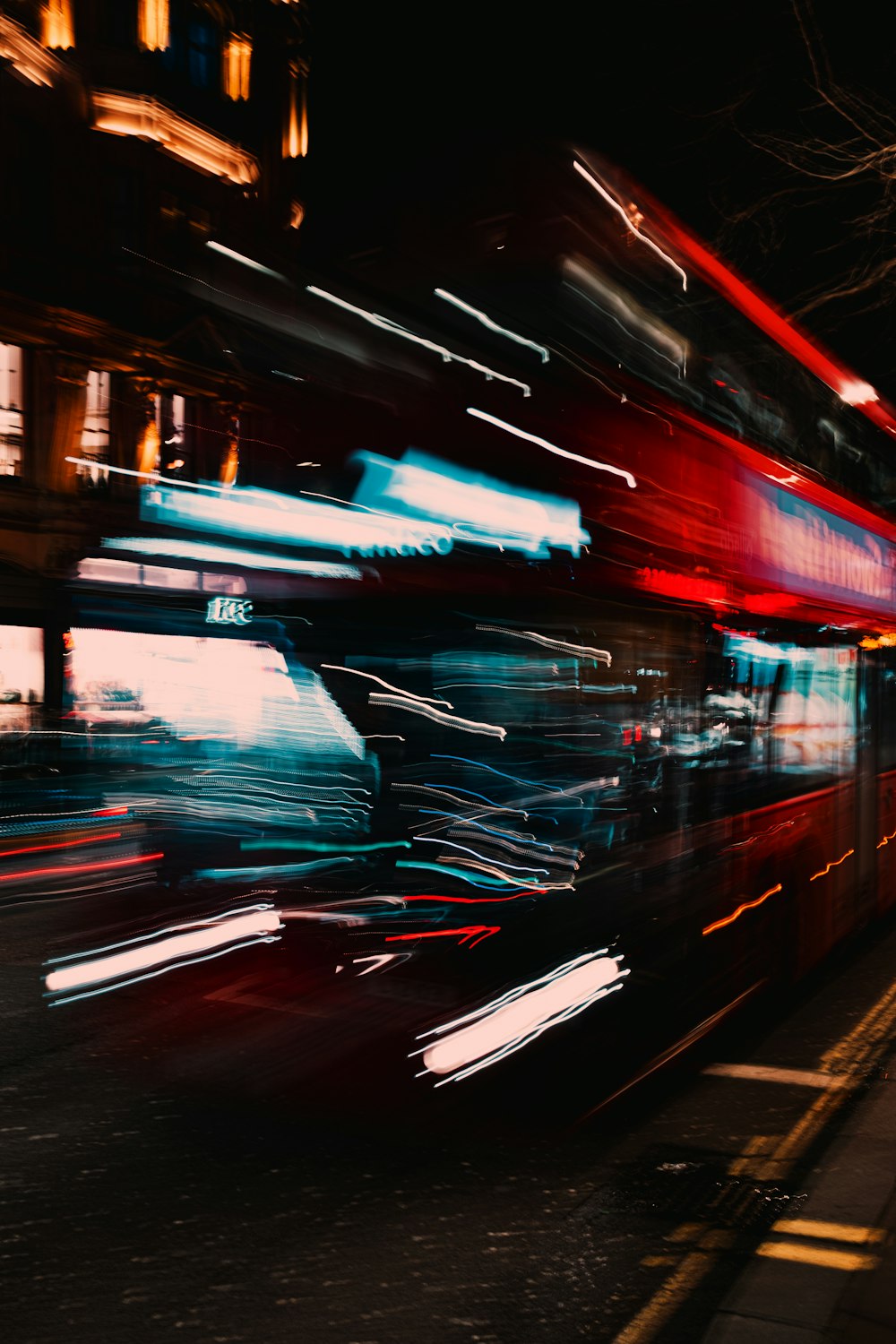 a double decker bus driving down a street at night