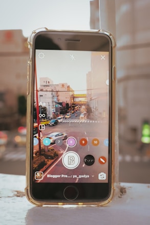 A sleek smartphone displaying a ride-hailing app interface with a cityscape in the background at dusk.