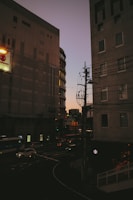 Technicians installing fiber optic cables along a city street at dusk.