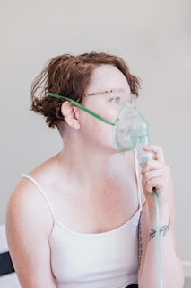 a woman in a white tank top with a mask on her face