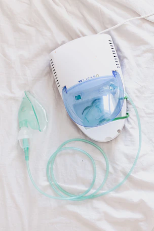 a ventilator and oxygen inhaler on a bed