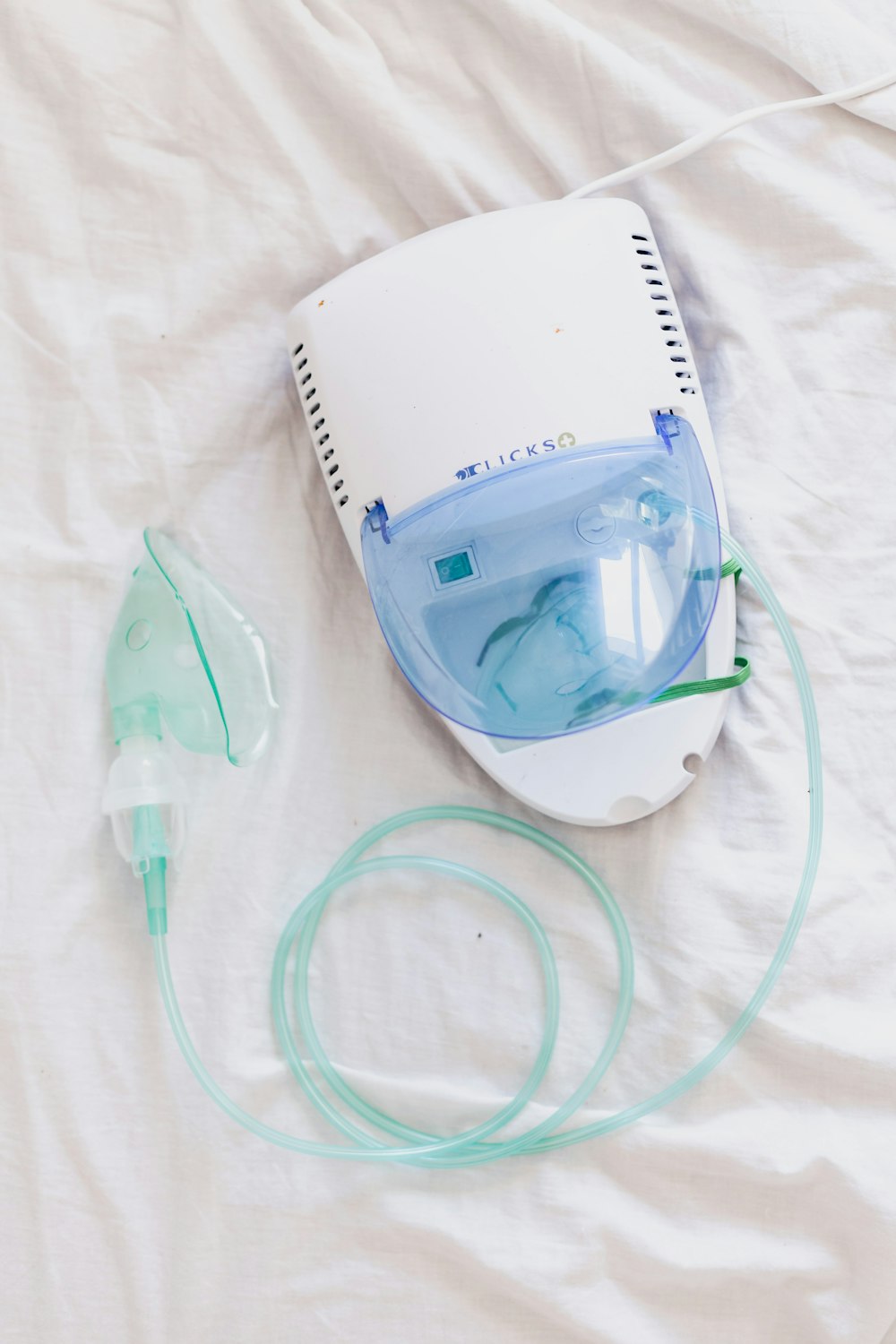 a ventilator and oxygen inhaler on a bed
