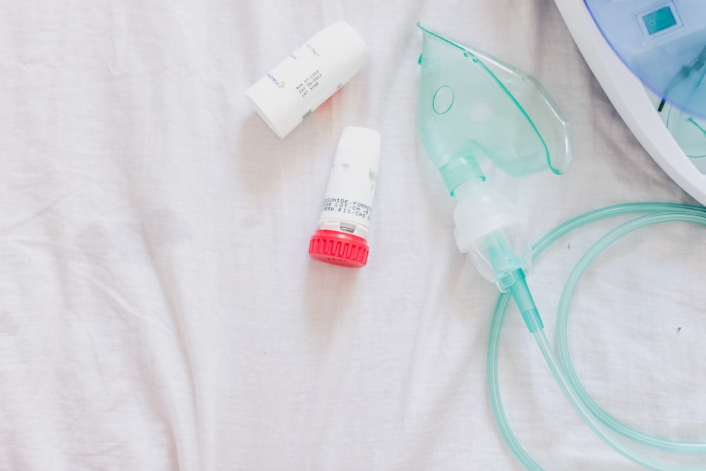 a close up of a bed with a device and a bottle