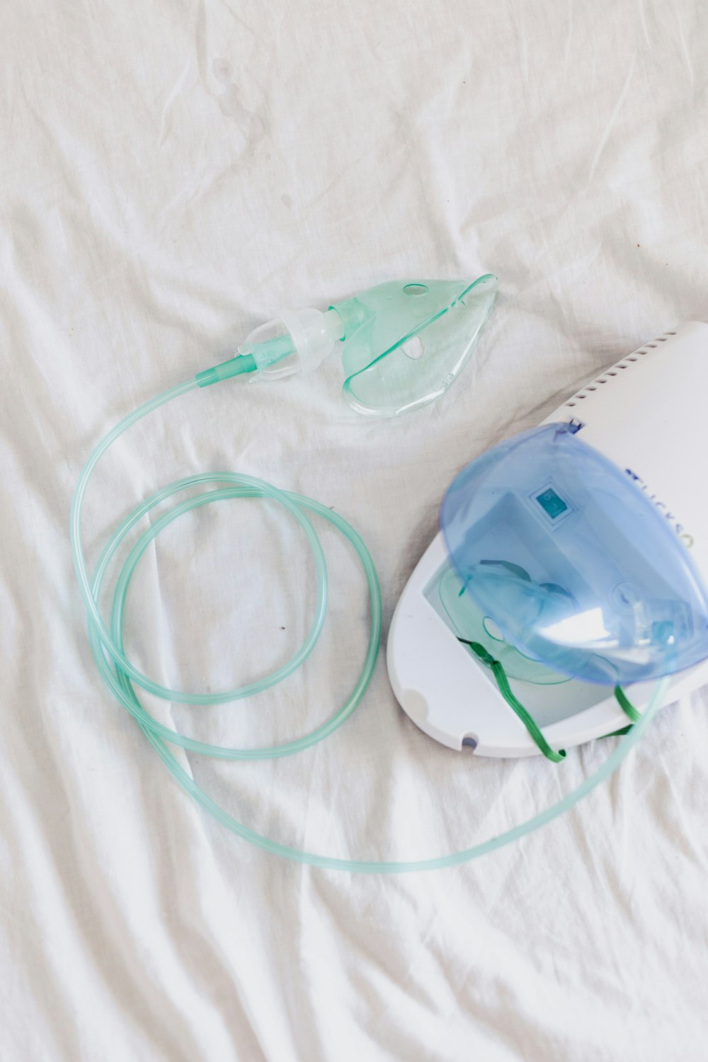 a white bed with a blue and green device on top of it