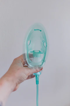 A sturdy hard oxygen chamber with a transparent door, showing a patient inside receiving therapy.