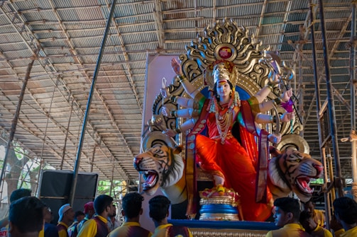 a large statue of a person sitting on top of a tiger