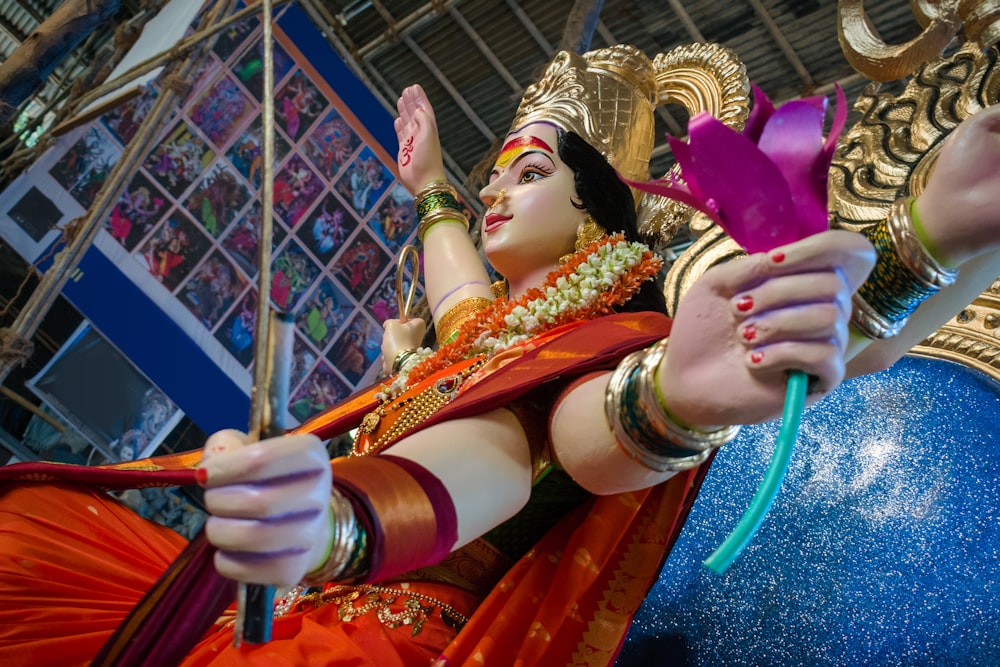 a statue of a woman holding a purple flower