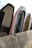 Several boats are placed vertically against a concrete barrier, with visible wear and paint peeling from their surfaces. The boats are lined up closely, showcasing various colors and the ropes hanging loosely.