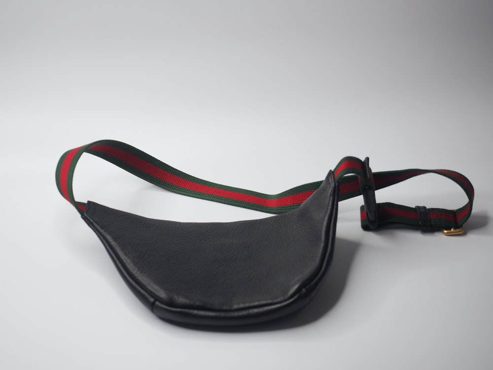 a black leather fanny bag with a red and green stripe