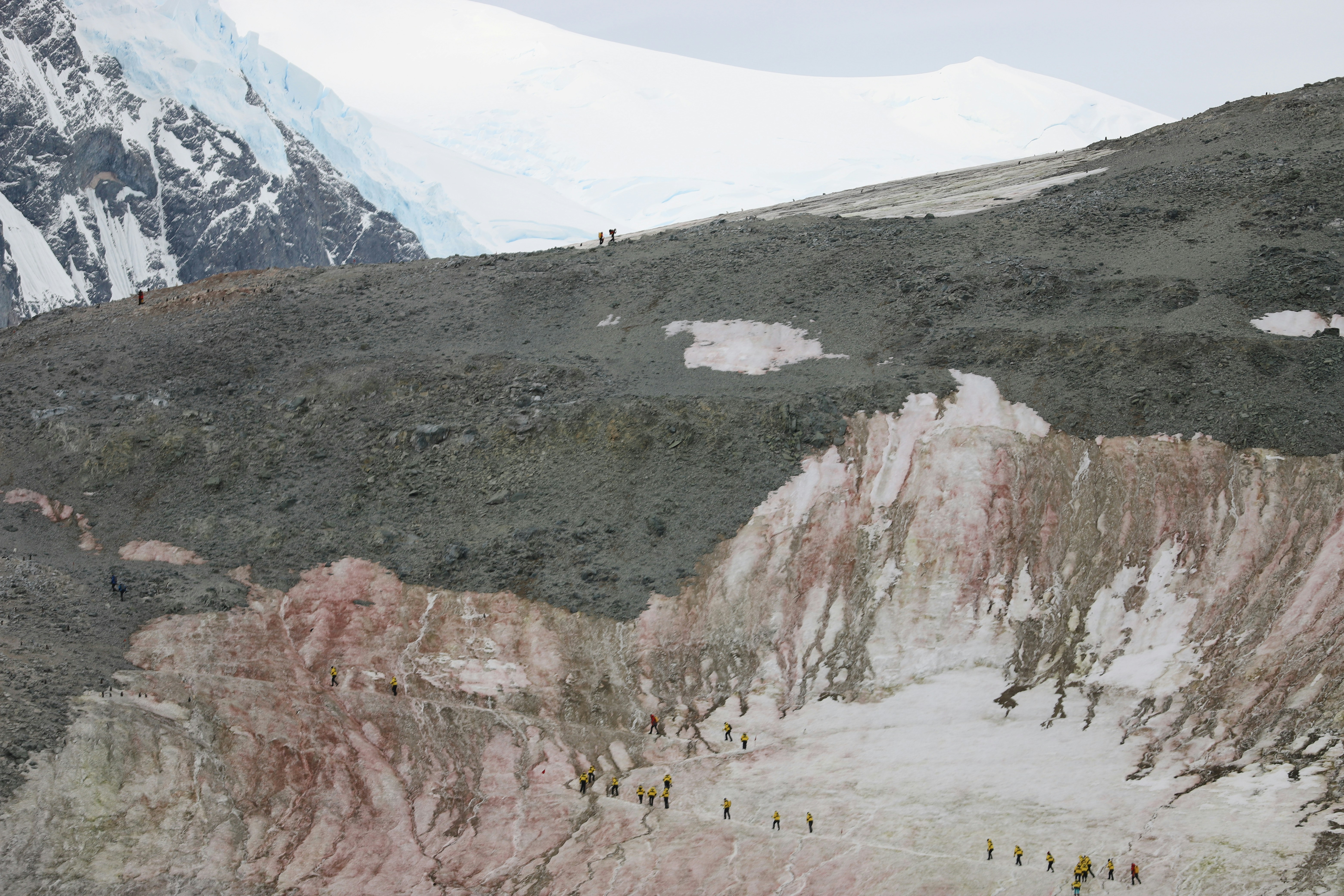 a group of people walking up the side of a mountain