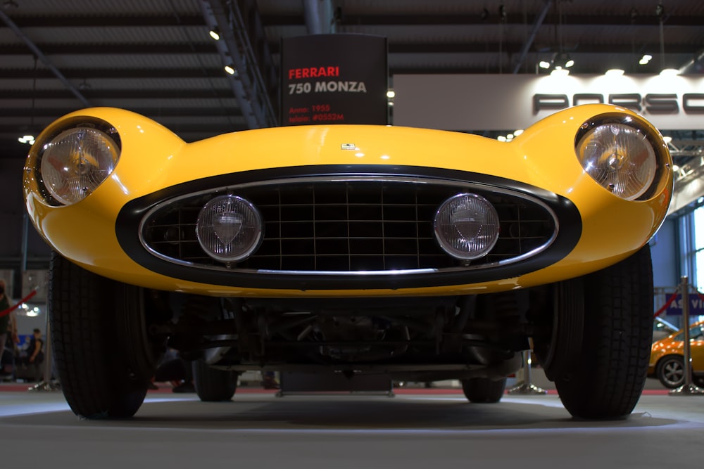 a yellow sports car is on display at a car show