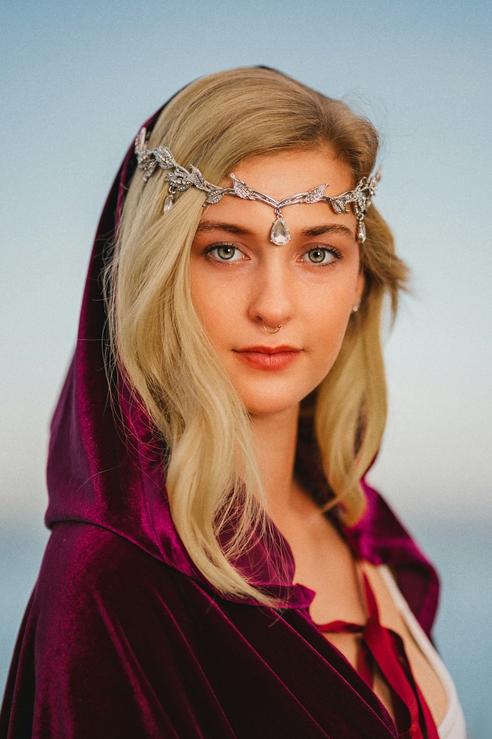 a woman in a red cloak with a chain around her head