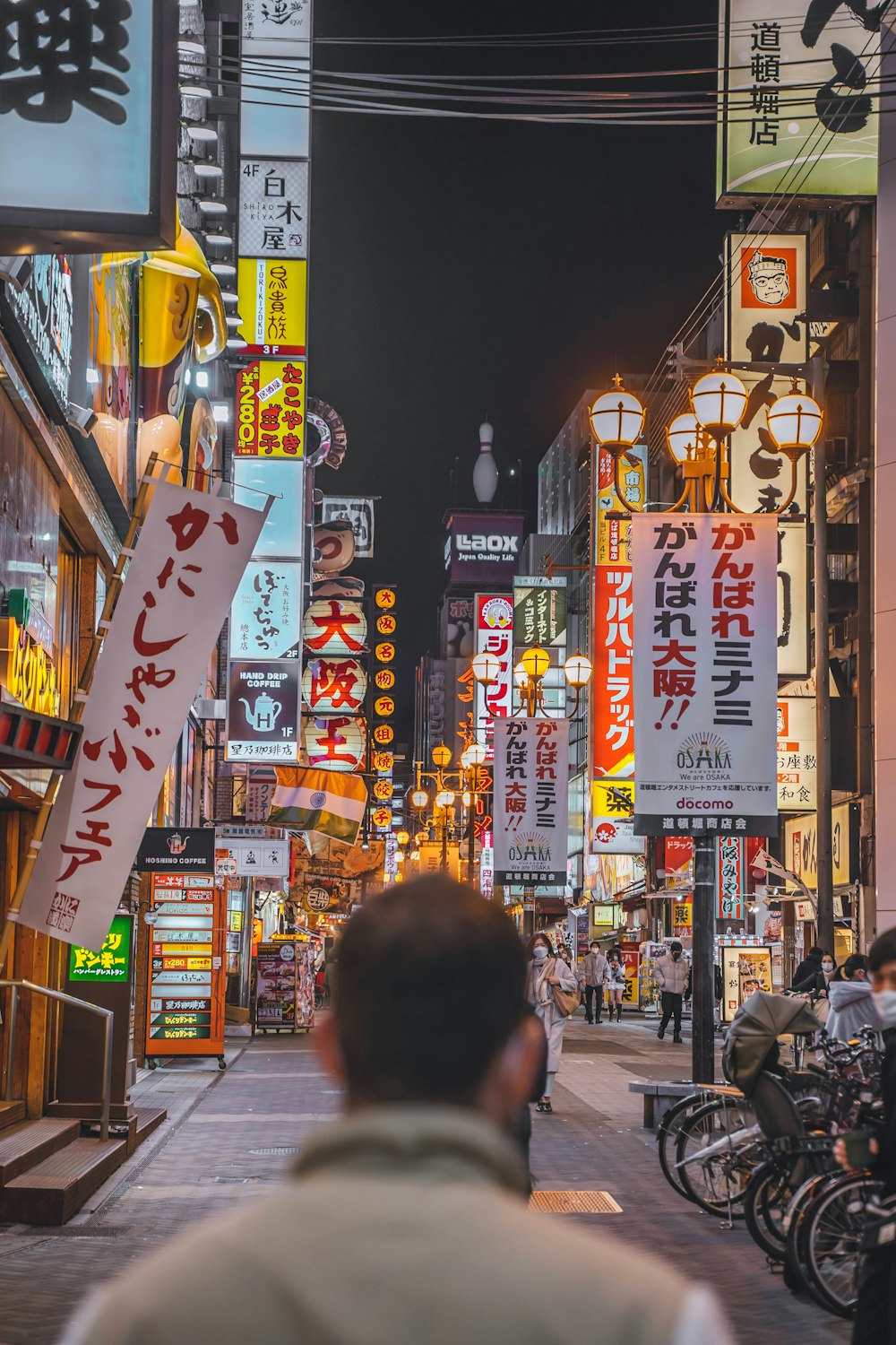 a man walking down a city street at night